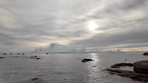 Golden hour sun shining through dramatic clouds over ocean seascape