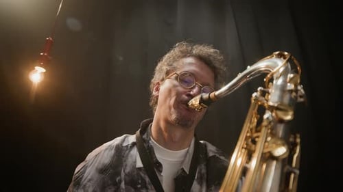 Saxophone Player Performing on Stage at Night