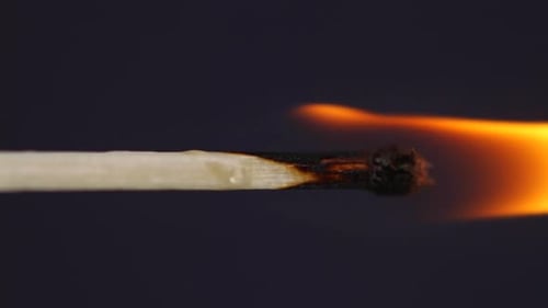Ignition matches close up macro shot captured in front of black background in slow motion at 60 fps.