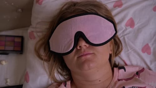 Woman Sleeping Peacefully in Bed with Eye Mask