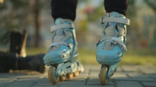 Personne attachant des sangles de patin à roulettes alors qu'elle est assise dans un parc
