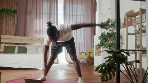 Young Man Stretching and Exercising at Home