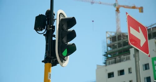 Traffic signal switching red to green, allowing pedestrians passing junction by crane, copy space