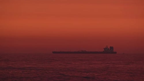Cargo ship floating in the Pacific ocean at dusk