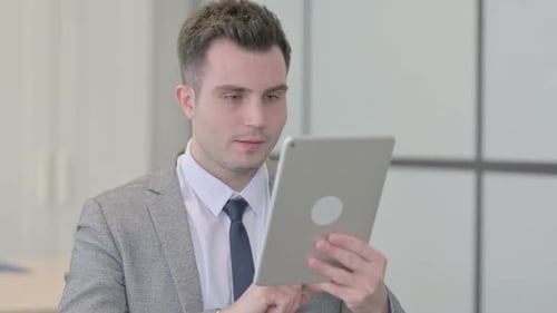 Man Smiling Using Tablet in Modern Workplace