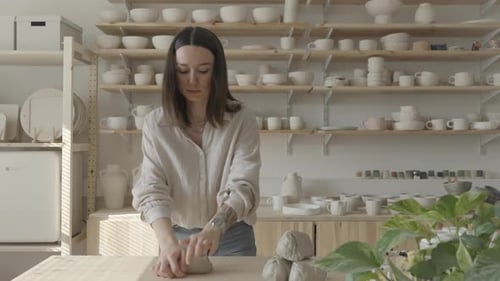 Woman Shaping Clay in Pottery Studio