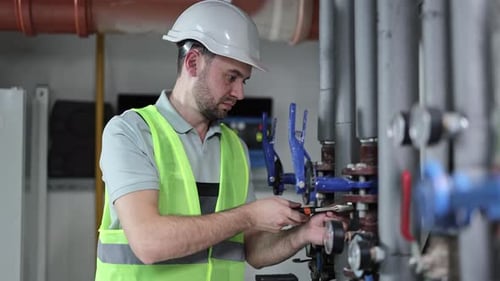 Man Working on Pipes in Industrial Setting