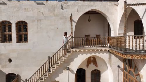 Woman Walks Down Stairs in Historical Building