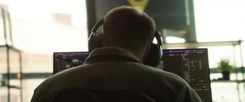 Man with Headphones Works at Computer