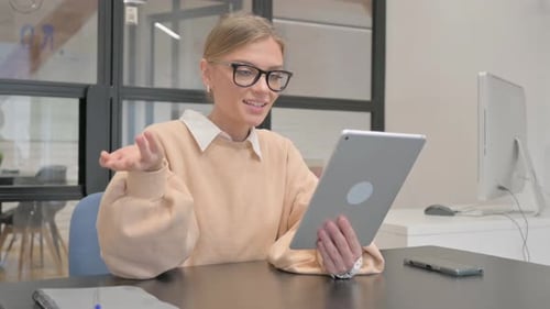 Female Worker Doing Video Chat on Tablet in Office