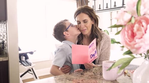 Boy gives Mother's Day card to happy mom