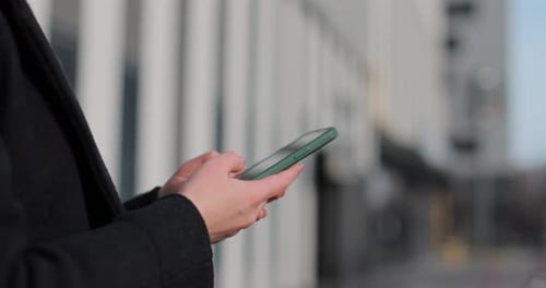 Woman Uses Cell Phone in Urban Setting