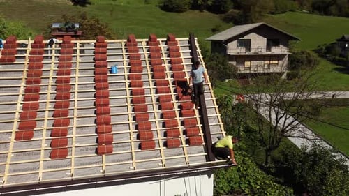 Men Tiling Roof of House in Rural Area