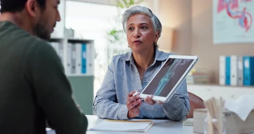 Doctor Explains X-Ray on Tablet to Patient