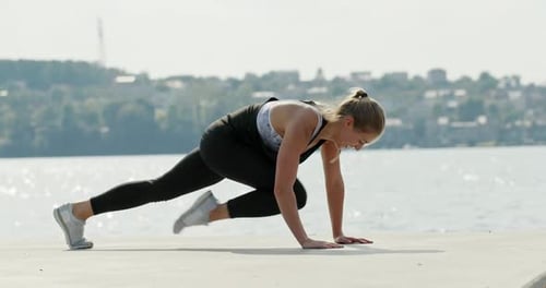 Young Woman Exercising on Embankment