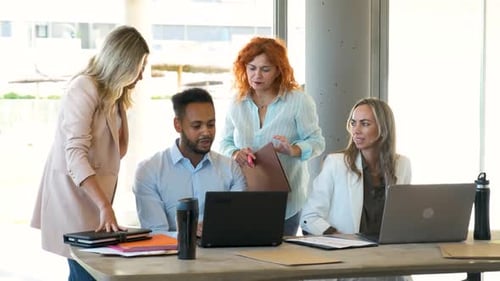 Diverse Team Collaborating in Office Looking at Laptop