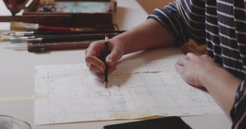 Close-up of Artist Drawing on Grid Paper