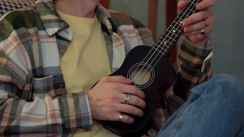 Man Plays Ukulele, Close-Up Indoor Shot