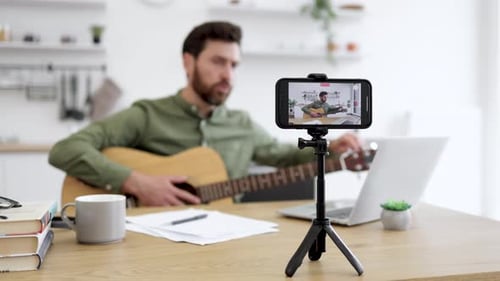 Man Records Guitar Lesson Video at Home