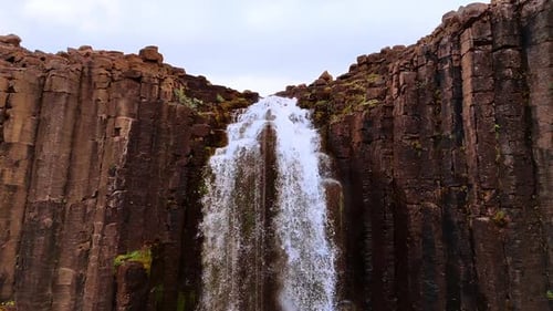 Wasserfall in der Basaltklippe. Wunderschöner Felsen mit der Säulenstruktur in Island. Drohnenaufnahmen.