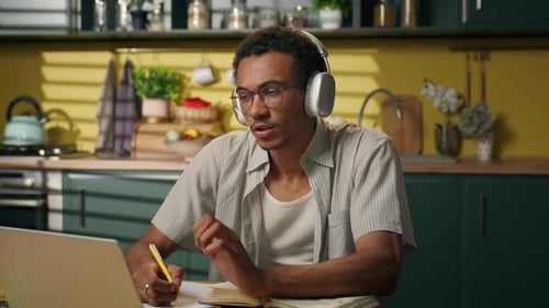 Young Adult Studying with Laptop at Home