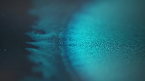 Abstract close-up of blue ink dispersing in water with a soft focus