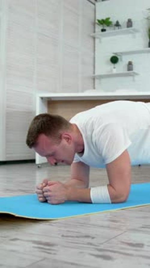 Man Does Plank Exercise on Yoga Mat