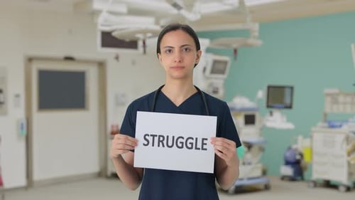Medical Professional Holds Sign: Struggle in Operating Room