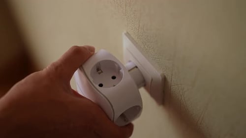 Closeup Top View of Unrecognizable Electrician Male Inserting White Electrical Outlet Tee or Triple