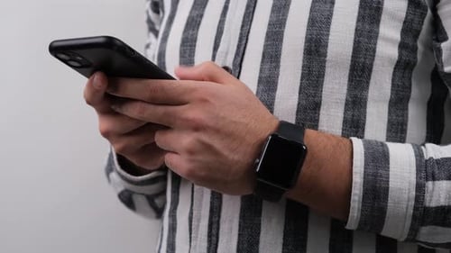 Young Adult Using Smartphone with Black Smart Watch