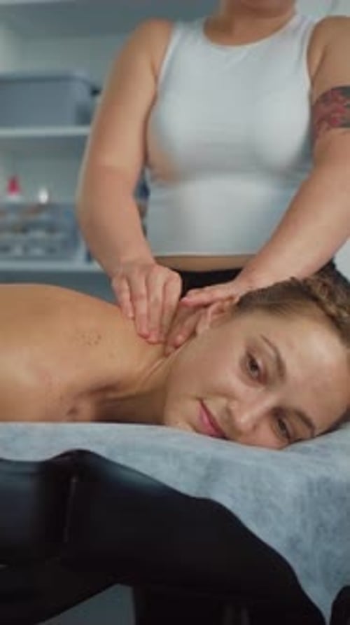 Young and Beautiful Woman Gets Massage Therapy in Spa Cabinet After Hard Stress Work Vertical