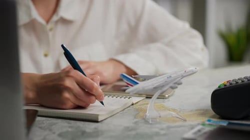 Woman Planning a Trip and Making Notes