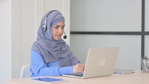 Muslim Woman in Hijab with Headset Talking with Customers Online in Call Center
