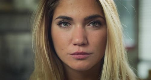 Authentic close up shot of an young blond hair attractive happy woman is smiling in camera in a li