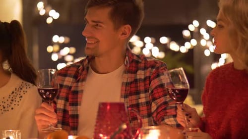 Friends enjoying dinner, talking, and drinking red wine