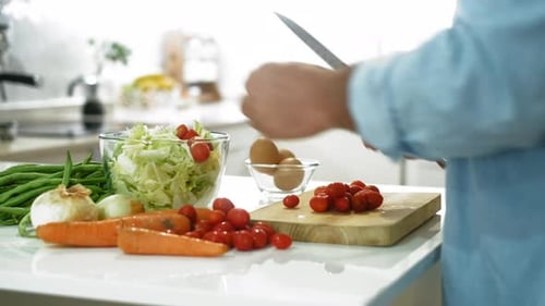 Nahaufnahme von Menschenhänden, die zu Hause in der Küche Gemüse schneiden und gesunde Salate zubereiten
