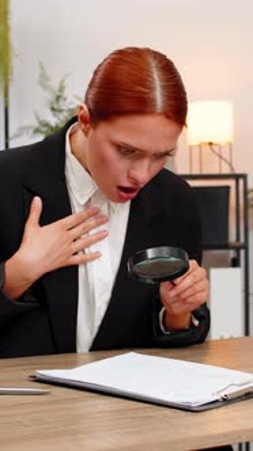 Young Businesswoman Examines Contract with Magnifying Glass and Gets Angry Discovering Concealed Fee