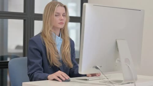 Smiling Woman Working on Desktop Computer in Office