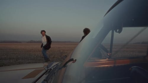 Couple Leaving Car and Running Freely across Field at Dusk