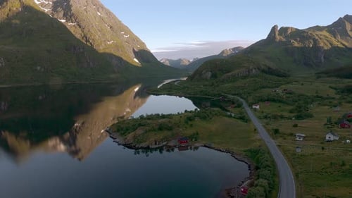 Idyllic red house on Lofoten island, Norway. Nature with sea, fjord, mountain and water reflections