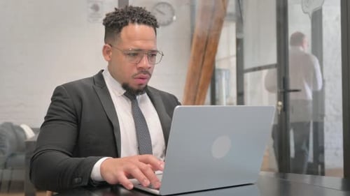 Young Adult Working on Laptop in Office