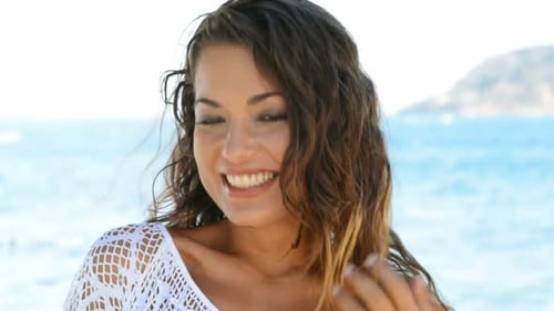 Beautiful Woman at Beach Looking at Camera. Smiling Young Woman in Front