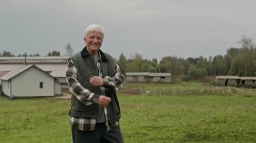Smiling Senior Man on Farm with Crossed Arms