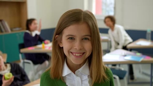 Elementary School Class Children Communicate with the Teacher Answering Question