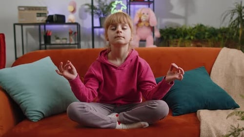 Child Doing Yoga Meditation at Home on Couch