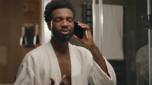 Attractive Man in Robe Talking on Phone in Bathroom