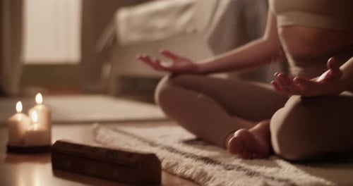 Female Meditating Near Aromatic Candles