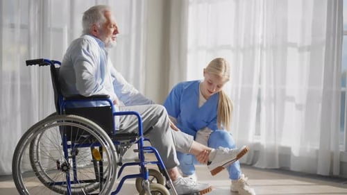 Medical Professional Examining Senior Patient in Wheelchair