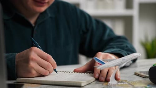 Young Adult Planning an Airplane Trip at Home
