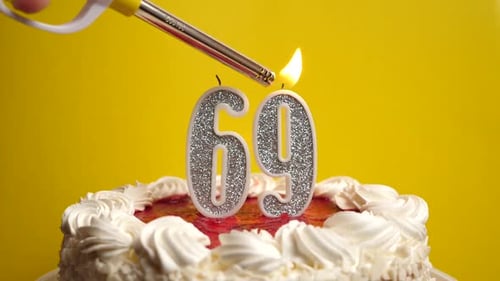 69. A candle in the form of the number 69, inserted into the holiday cake, is lit. Celebrating a bir